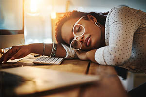 kleine levin syndrome - woman asleep at desk